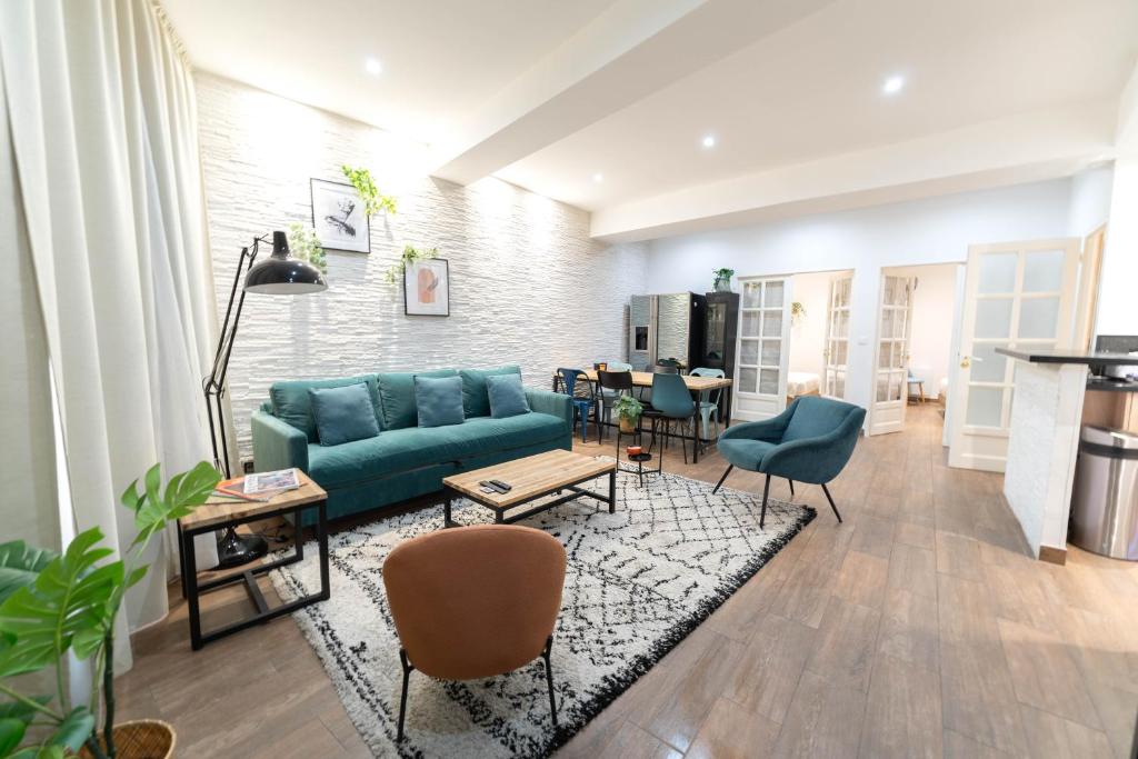 un salon avec un canapé bleu et des chaises dans l'établissement Bel appartement en plein cœur de la vieille ville, à Nice