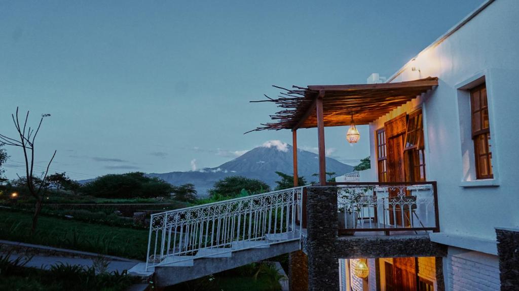 a building with a balcony with a view of a mountain at Mateves boutique lodge in Arusha