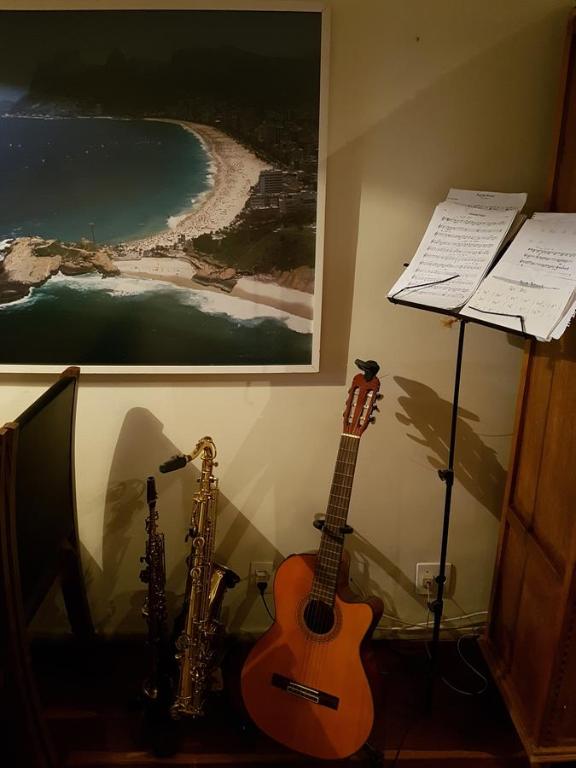 una guitarra y un saxofón sentados junto a una pared en Copacabana Paraiso Tropical, en Río de Janeiro