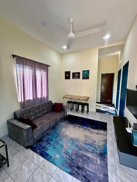 a living room with a couch and a table at Teratak Manis Homestay in Kuantan