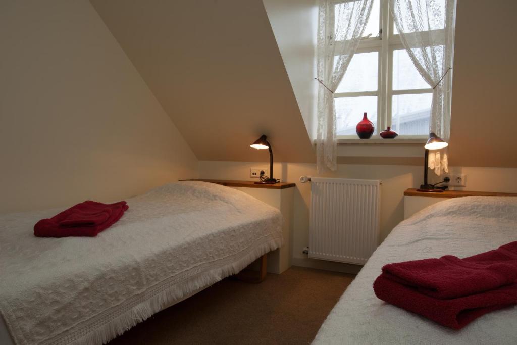 una camera mansardata con due letti e una finestra di Guesthouse Gamla a Ísafjörður