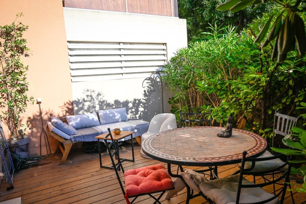 un patio avec un canapé, une table et des chaises dans l'établissement Charmant appartement avec jardin à 500m des plages Prado Borely, à Marseille