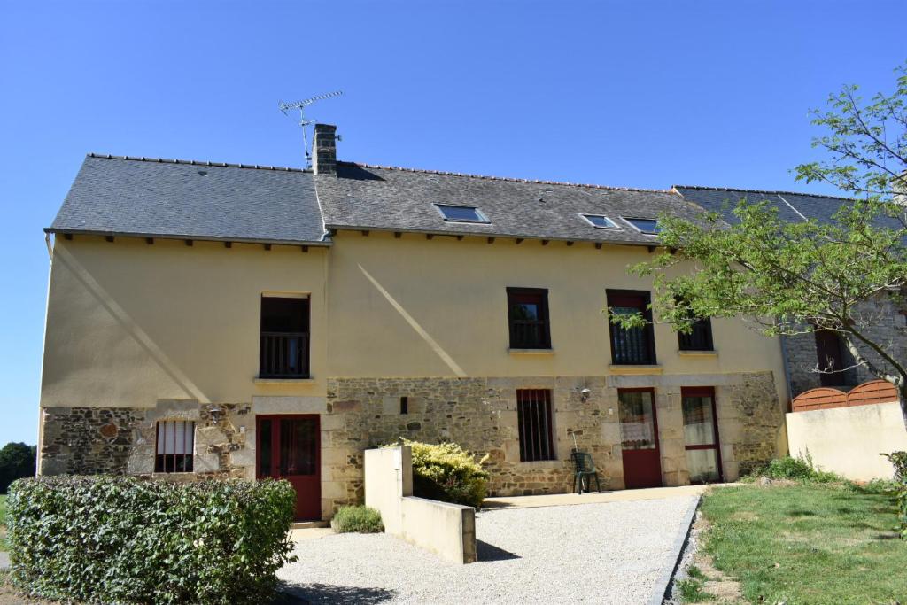 une ancienne maison en pierre avec des portes rouges dans l'établissement La Prairie, à La Celle-sous-Gouzon