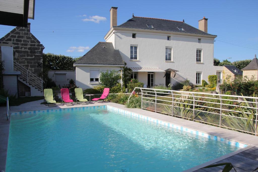 a swimming pool in front of a house at Doué's Mansion in Doué-la-Fontaine