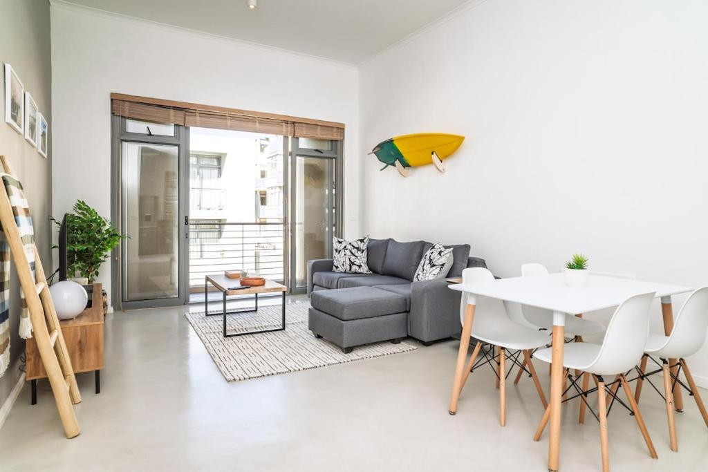a living room with a couch and a table at Muizenberg Coastal Hideaway by Surfers Corner in Muizenberg