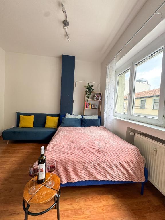 a bedroom with a bed and a table with a bottle of wine at Old town cozy Studio in City Center in Bratislava