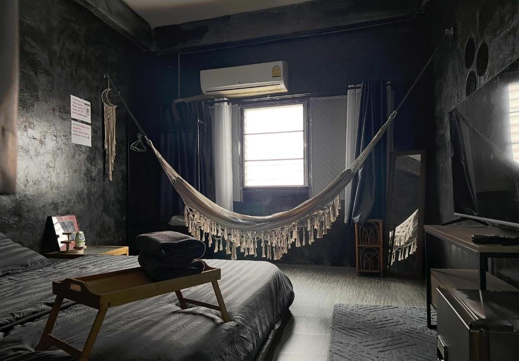 a bedroom with a hammock hanging from a window at Stay Strays Hostel in Bangkok