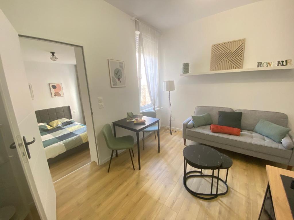 un salon avec un canapé, une table et un lit dans l'établissement Appt RDC Jardin Laverie Parking Villa Margareth, à Dunkerque