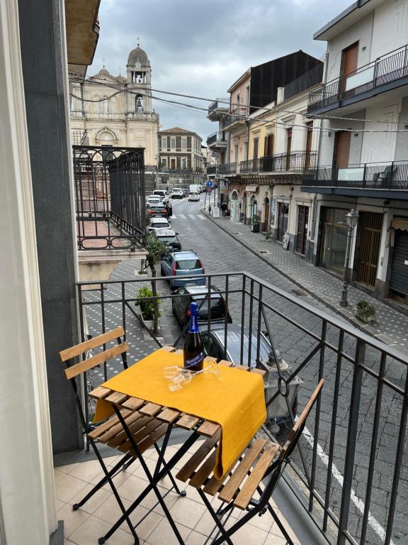 a table and chairs on a balcony with a street at Casa Vacanze Happy Home in Zafferana Etnea