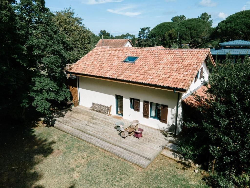 Cette petite maison blanche dispose d'une grande terrasse en bois. dans l'établissement Maison de vacances Le Bosquet, à Saint-Julien-en-Born