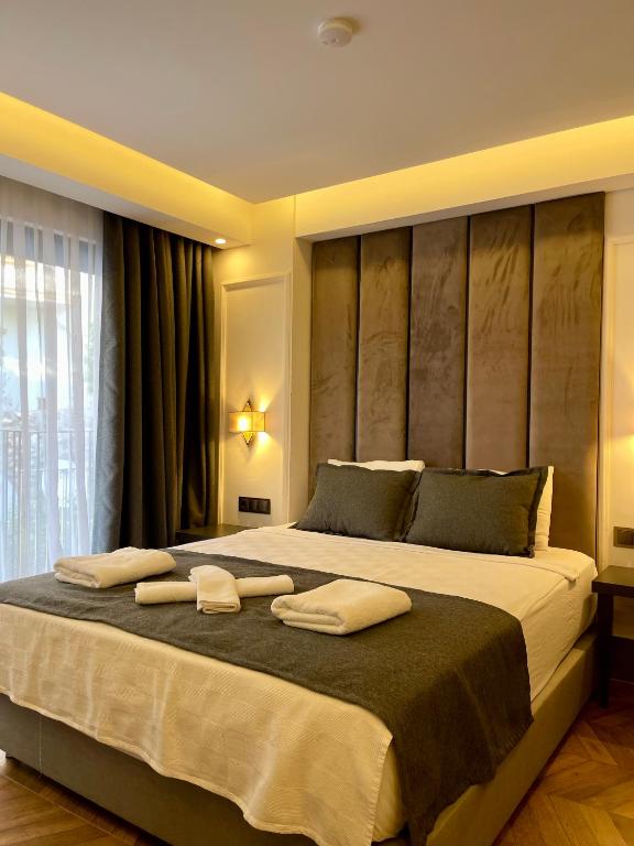 a bedroom with a large bed with two towels on it at Brow City Kaş in Kaş