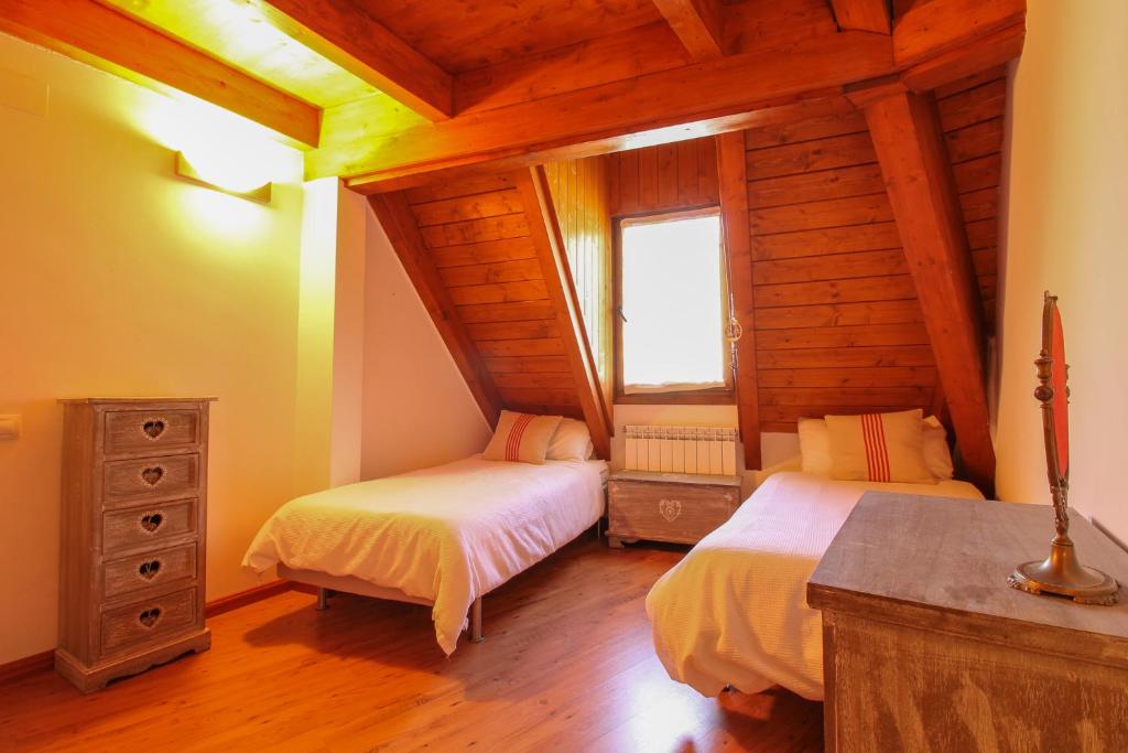 una camera con 2 letti in una baita di tronchi di El Betato a Tramacastilla de Tena
