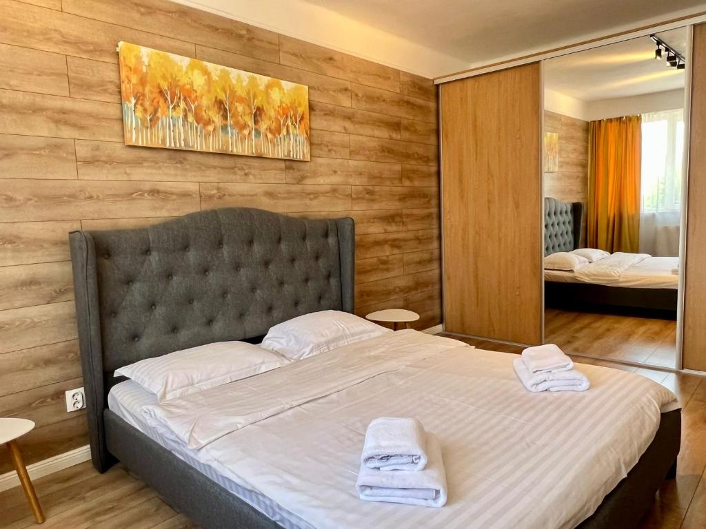 a bedroom with a large bed with two towels on it at Cozynest No 42 in Cluj-Napoca