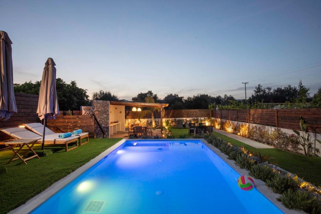 a swimming pool in a backyard with a patio furniture at Kathy's apartments in Archaggelos in Archangelos