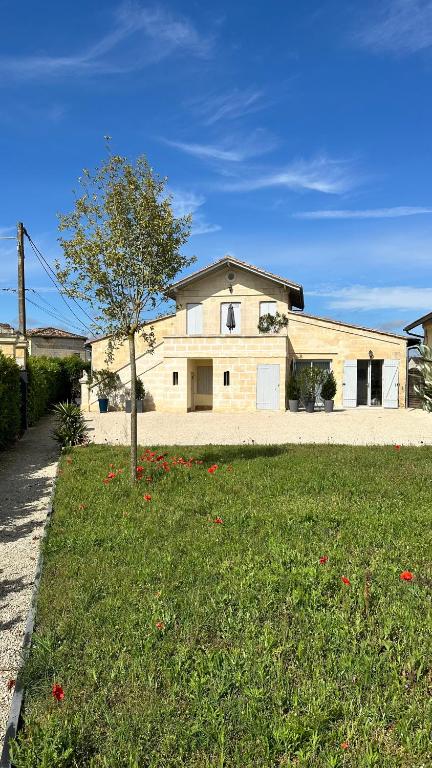 une maison blanche avec un arbre dans une cour dans l'établissement LA MAISON DES VIGNES SAINT EMILION, à Saint-Émilion