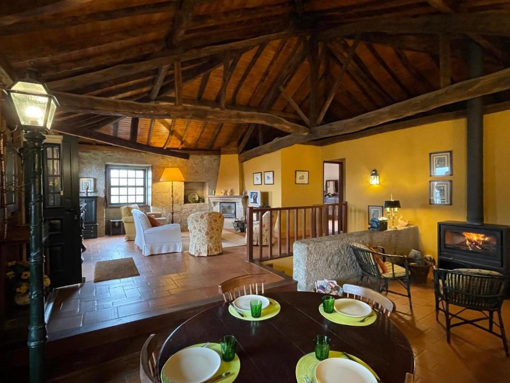 a living room with a table and chairs and a fireplace at Casa do Vale - Douro Valley Cottage in Resende