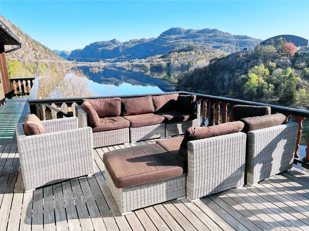 a porch with wicker chairs and a couch on a deck at Feriehus i Flekkefjord med panoramautsikt in Flekkefjord