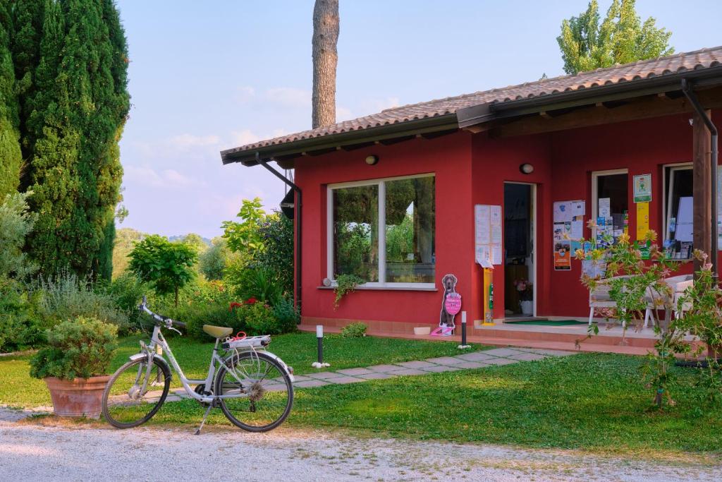 a bike parked in front of a red house at Camping Trasimeno in Passignano sul Trasimeno