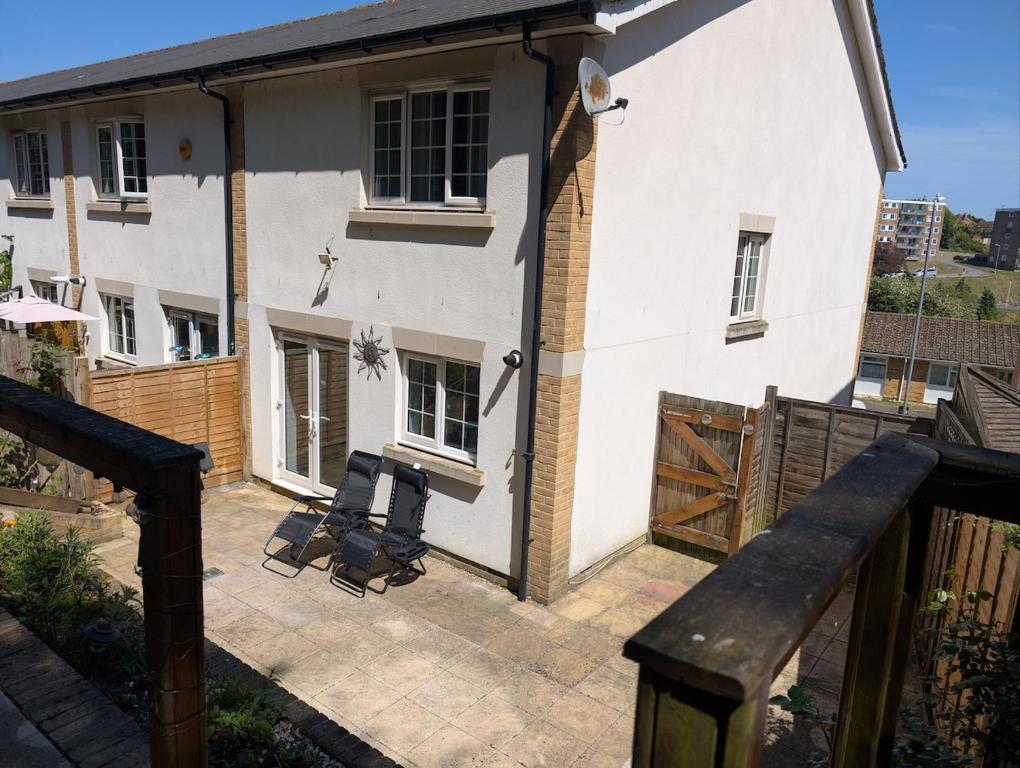 a white house with a patio in front of it at Enbrook Luxury Lodge with Garage and Driveway in Shorncliffe Camp