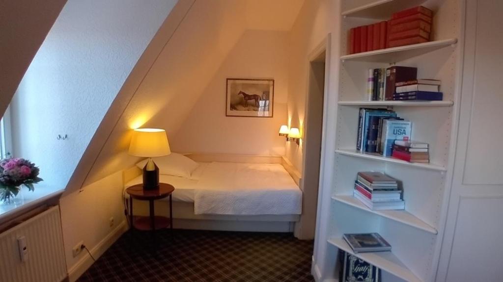 ein Schlafzimmer mit einem Bett und einem Bücherregal in der Unterkunft Herrenhaus Appartement 16 in Lüdersburg