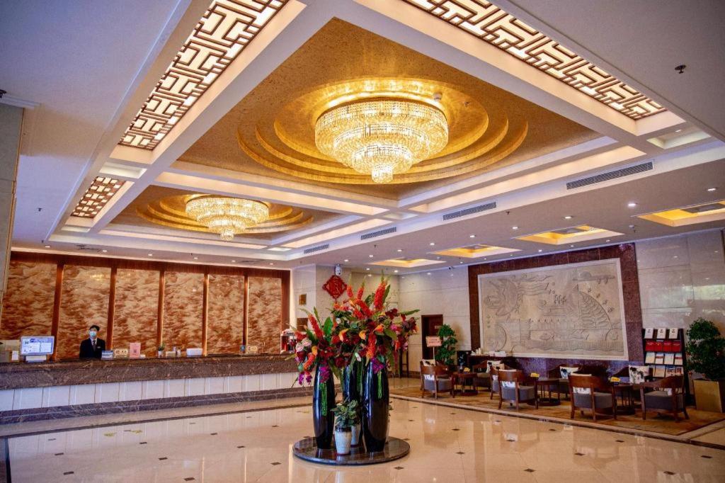 un hall d'hôtel avec une réception et des fleurs dans le hall dans l'établissement Liyuan Hotel, à Shenzhen