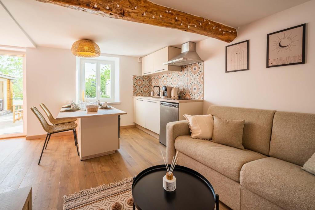 a living room with a couch and a table at La Bastide - Terrasse - Jacuzzi in Carcassonne