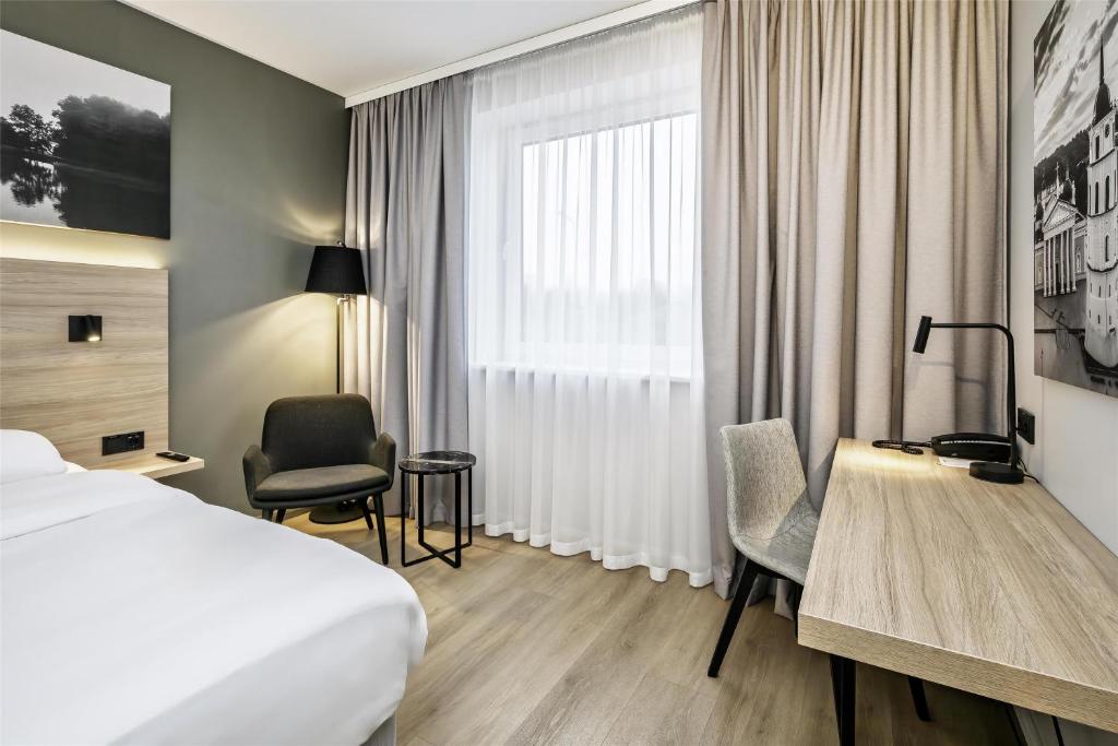 a hotel room with a bed and a desk at Park Inn by Radisson Vilnius Airport Hotel & Conference Centre in Vilnius
