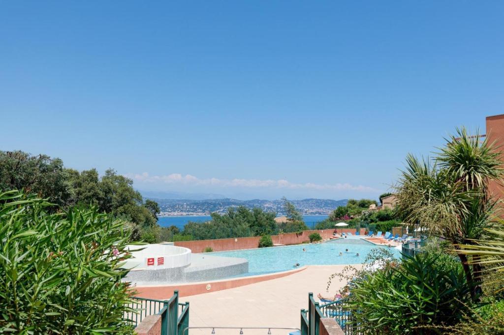 une vue d'une piscine dans un complexe hôtelier dans l'établissement Serenity apprt, à Théoule-sur-Mer