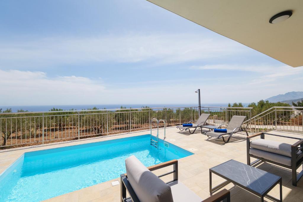 a patio with a swimming pool and chairs at Chryselia Suites- Private Pool in Keratokampos