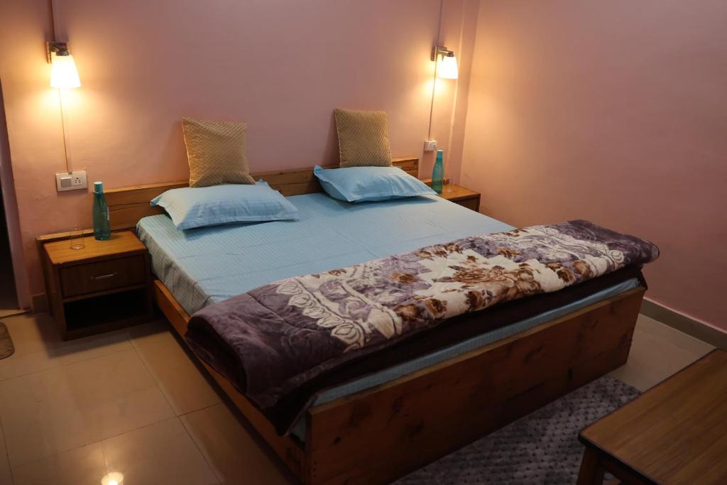 een slaapkamer met een bed met twee kussens erop bij Tirthan Living Green Home Stays in Banjār