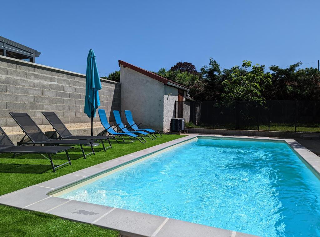 - une piscine avec 2 chaises longues et un parasol dans l'établissement Maison 6 personnes, Piscine privée, jardin, à Moulins