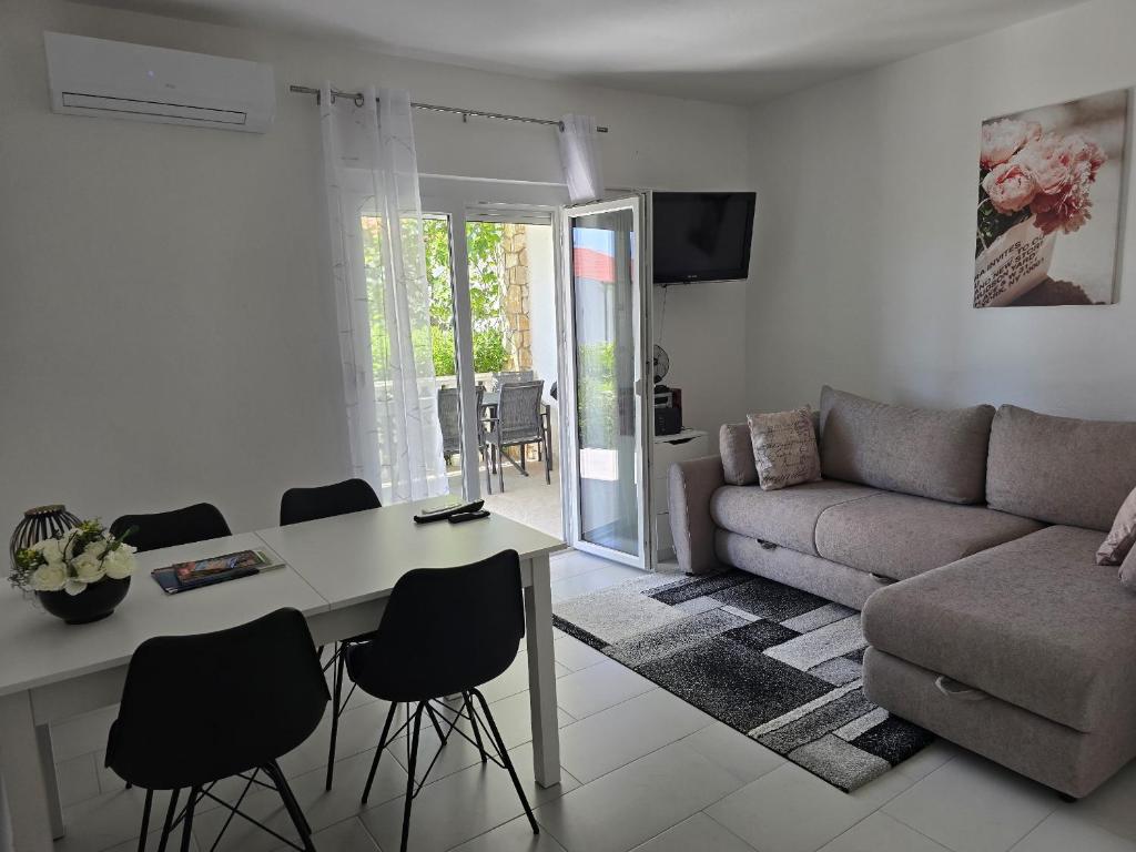a living room with a couch and a table and chairs at Apartment Benda in Pag
