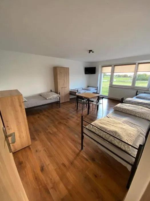 a room with beds and a table in it at Noclegi Rychwał in Rychwał