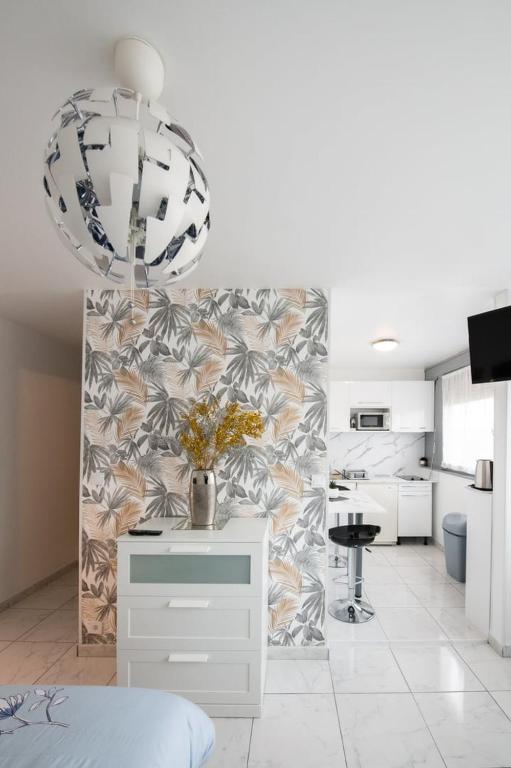 biały pokój z kuchnią i stołem z kwiatami w obiekcie Le Jasseron - Appartement cosy avec garage quartier PartDieu w mieście Lyon