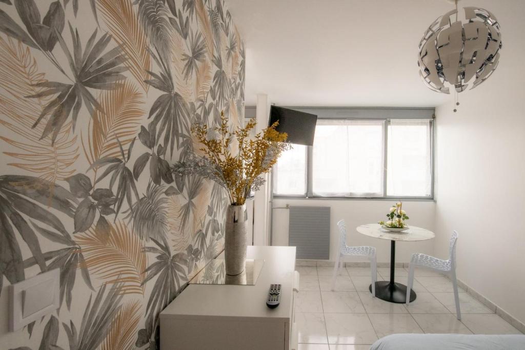 salon z wazą kwiatów na ścianie w obiekcie Le Jasseron - Appartement cosy avec garage quartier PartDieu w mieście Lyon