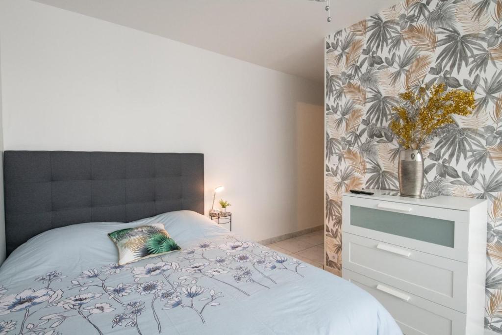 sypialnia z łóżkiem z czarnym zagłówkiem w obiekcie Le Jasseron - Appartement cosy avec garage quartier PartDieu w mieście Lyon