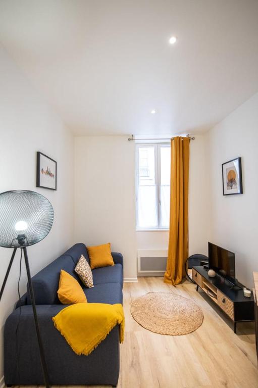 un salon avec un canapé bleu et une télévision dans l'établissement L'Opéra 9-Joli studio proche Opéra/Hôtel de Ville, à Lyon