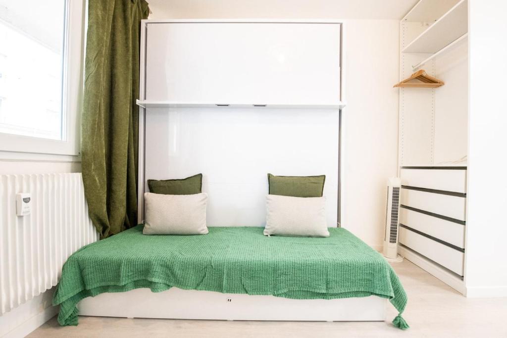 une chambre avec un lit avec une couverture verte dans l'établissement Le Paul B - Green, à Lyon