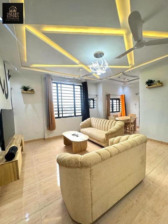 SMART BÂTIPRO Appartement 2 chambres salon 1 في كوتونو: غرفة معيشة كبيرة مع أريكة وطاولة