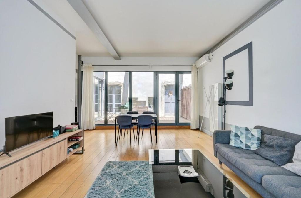 un salon avec un canapé et une table dans l'établissement Appartement avec terrasse, à Arles