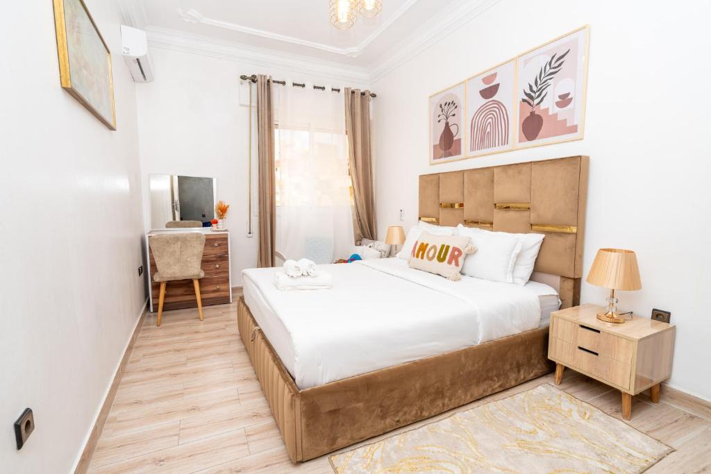 a bedroom with a large bed and a desk at Appartement Ensolleillé Au coeur De Tanger in Tangier