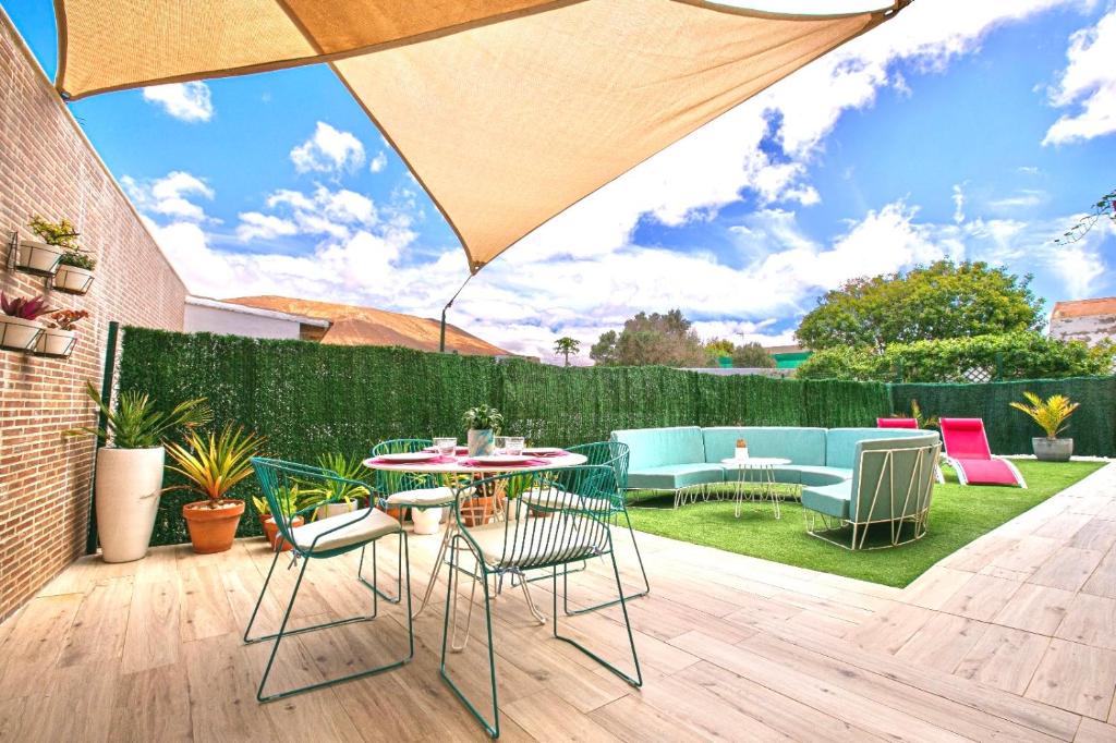 a patio with a table and chairs and an umbrella at CASA MIMAR moderna y acogedora in La Oliva