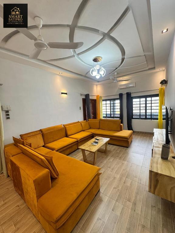 a living room with a couch and a table at SMART BÂTIPRO Appartement 2 chambres salon milieu in Cotonou