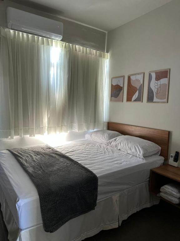 Un dormitorio con una cama grande con ventana. en Emas hotel, en Mineiros