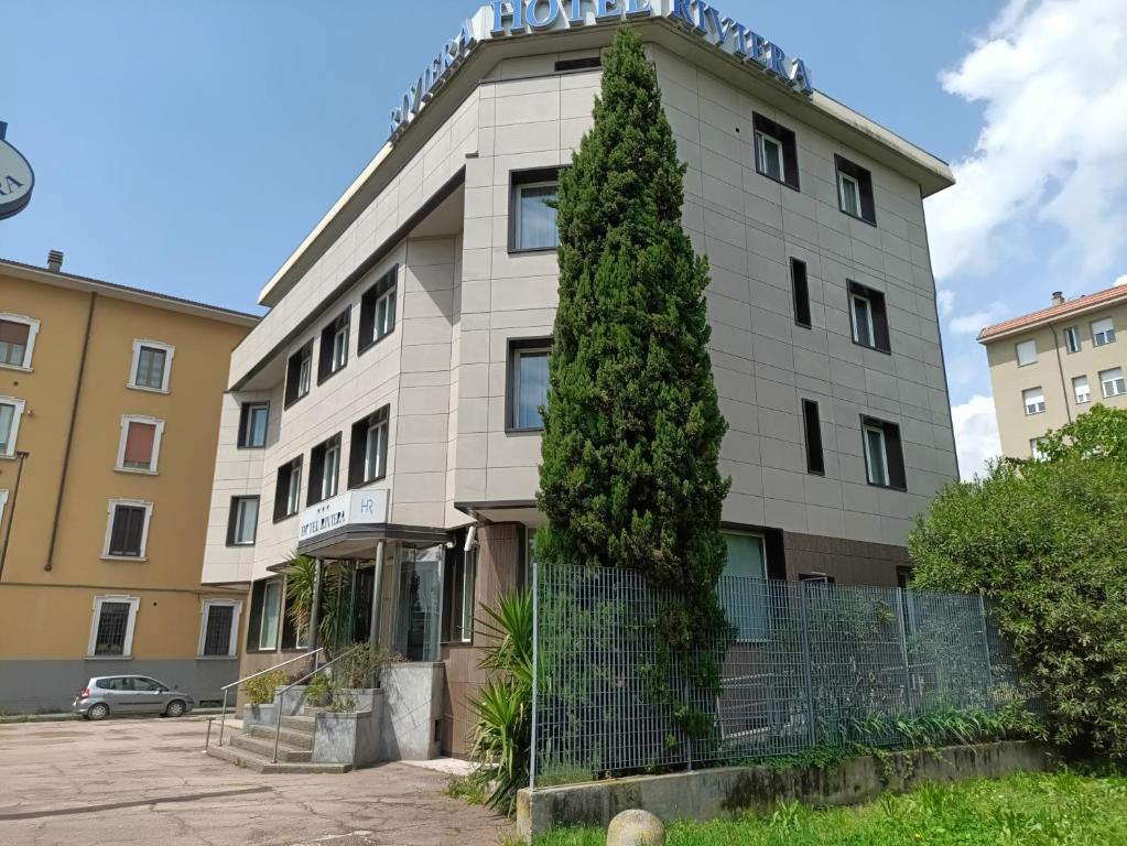 セグラーテにあるホテル リヴィエラの前に木がある建物
