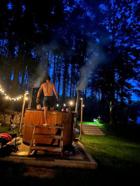 a man standing on top of a wooden table at Domek pod sosnami in Ełk