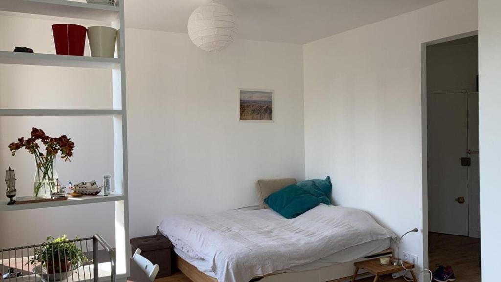- une chambre avec un lit dans un mur blanc dans l'établissement studio lumineux avec vue sur le canal, à Paris