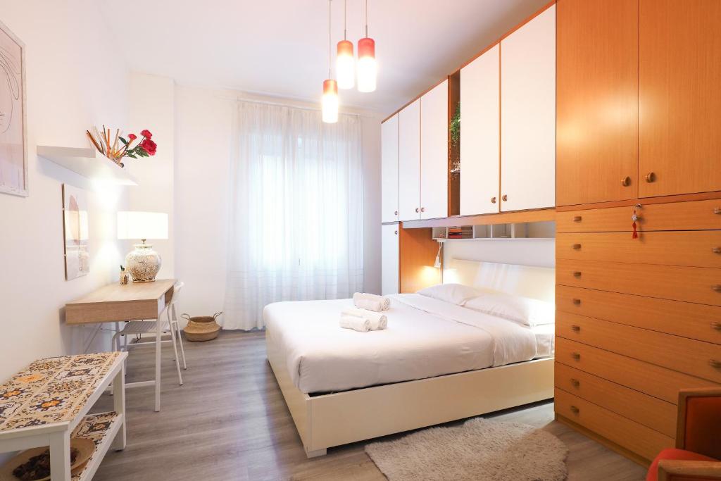 a bedroom with a bed and a table and a desk at PrimoPiano - Padova 217A in Milan
