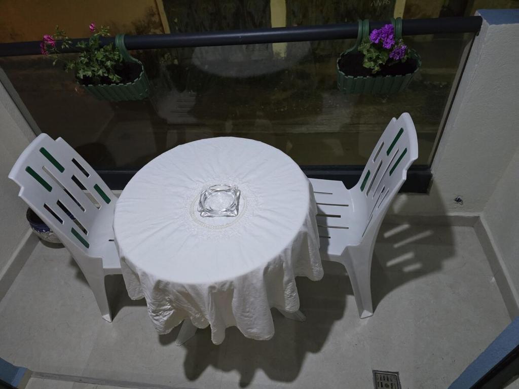 a white table with two chairs and a plate on it at Chic 2BR Apt - Walk to Beach in Essaouira
