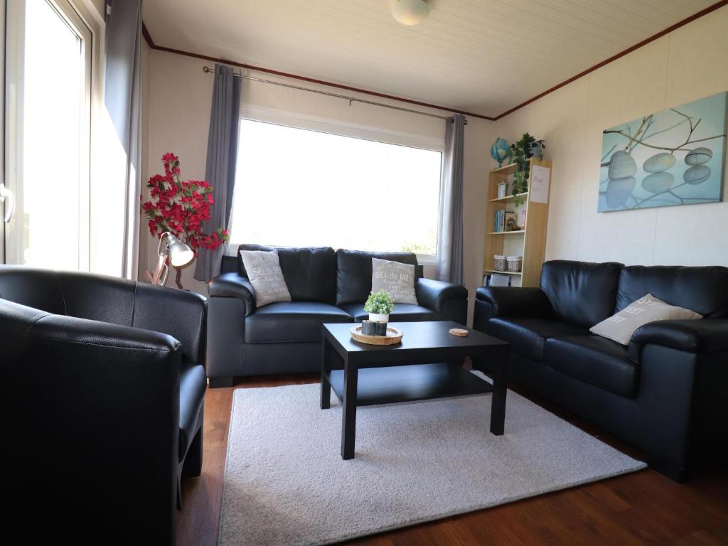 a living room with couches and a coffee table at Chalet in Friesland near Wadden Sea in Tzummarum